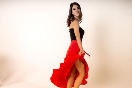 一位身着红色连衣裙的快乐女子，在室内优雅旋转，尽显幸福
