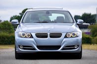 一辆蓝色现代轿车停在乡村道路上，尽显奢华与设计感