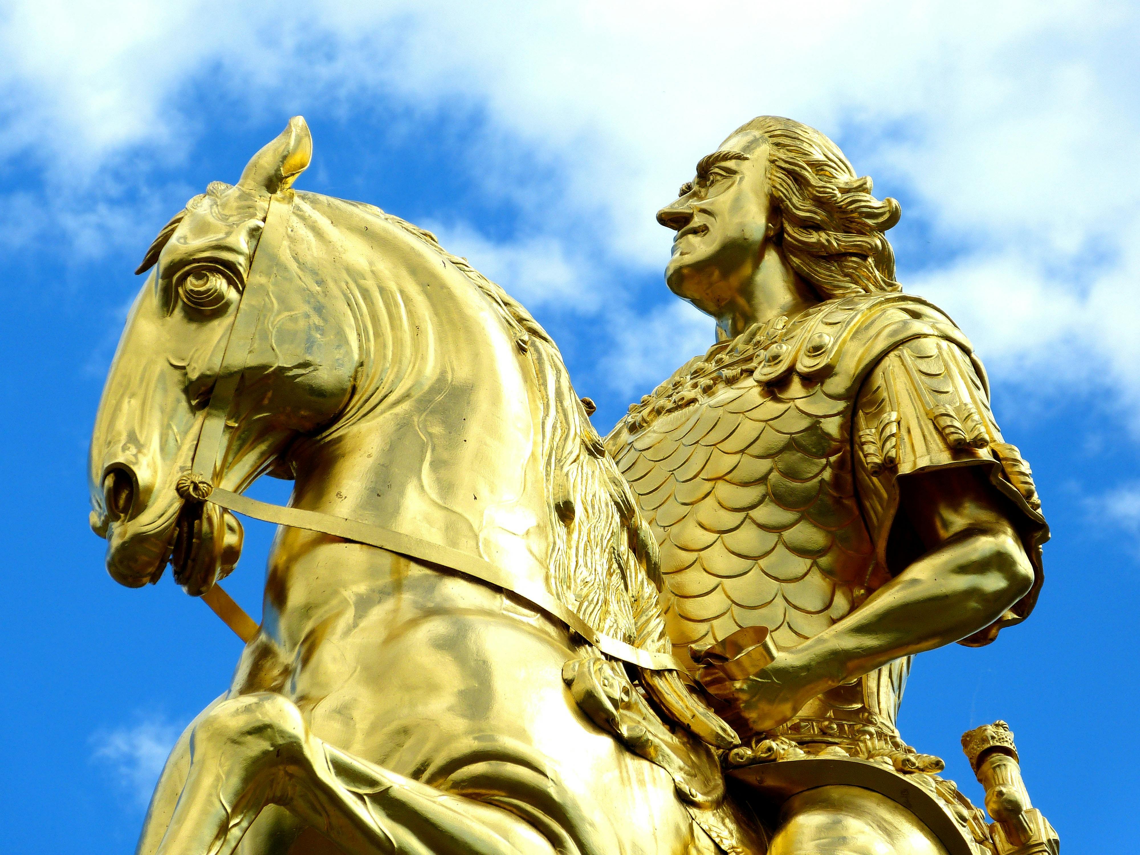 golden statue under blue skies during day time