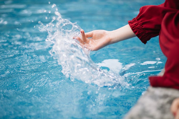 Woman Hand Splashing Water In Pool