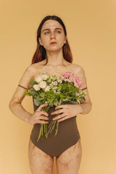 一名女子脸上有明显伤疤，她拿着一束鲜花，背景是米色的