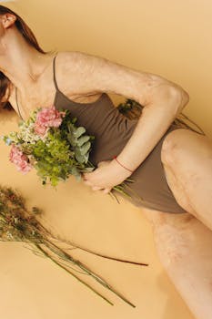 一位身穿棕色泳衣的女子，手持鲜花，肖像背景为黄色