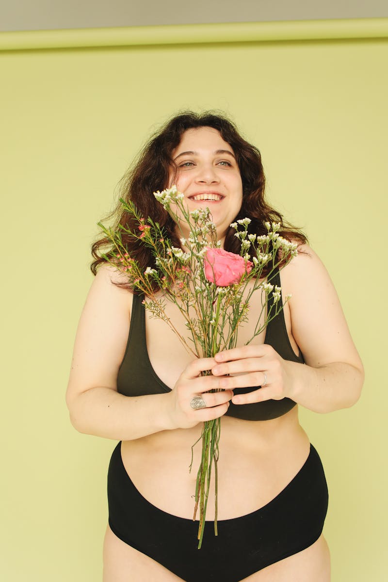 Woman in Black Tank Top Holding Bouquet of Flowers