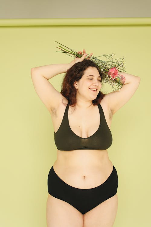 A Plus Size Woman Holding Stem of Flower while Posing at the Camera