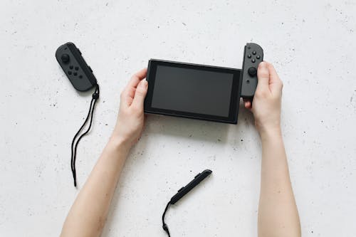 Hands Removing the Controller of Nintendo Switch