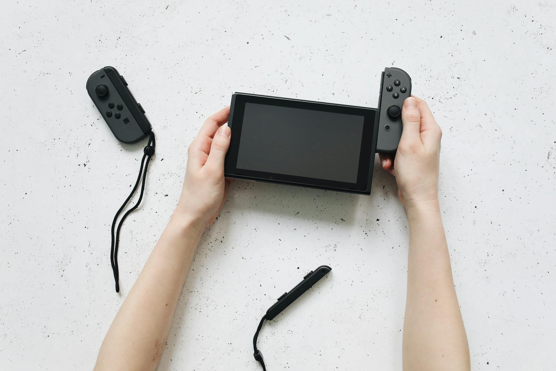 Hands Removing the Controller of Nintendo Switch