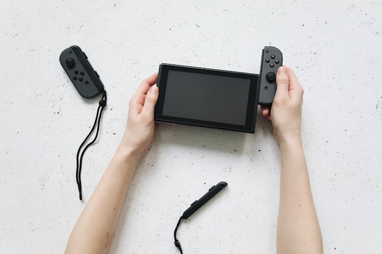 Hands Removing The Controller Of Nintendo Switch