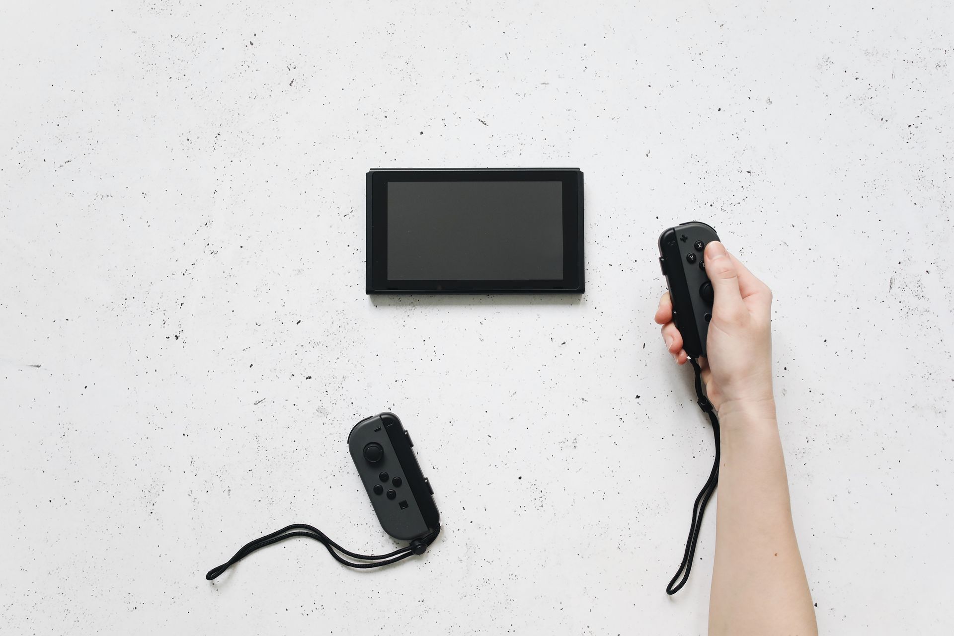 A Hand Holding the Removable Controller of Nintendo Switch
