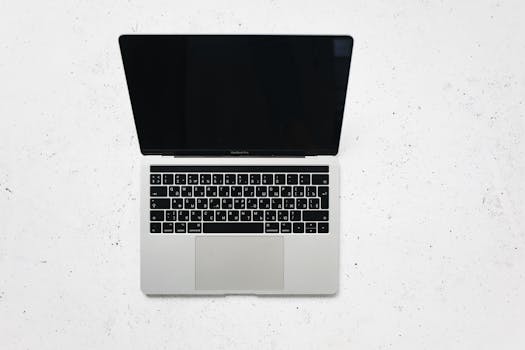 A sleek open laptop placed on a white marble surface, captured from above.