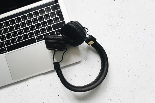 Free Overhead view of a laptop and headphones on a stylish marble background. Stock Photo