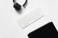 White and Silver Wireless Keyboard on White Marble Surface