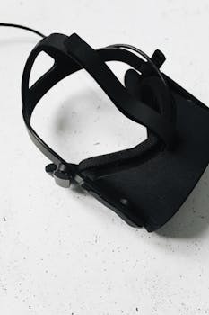 Minimalist black VR headset on textured white surface, perfect for tech themes.