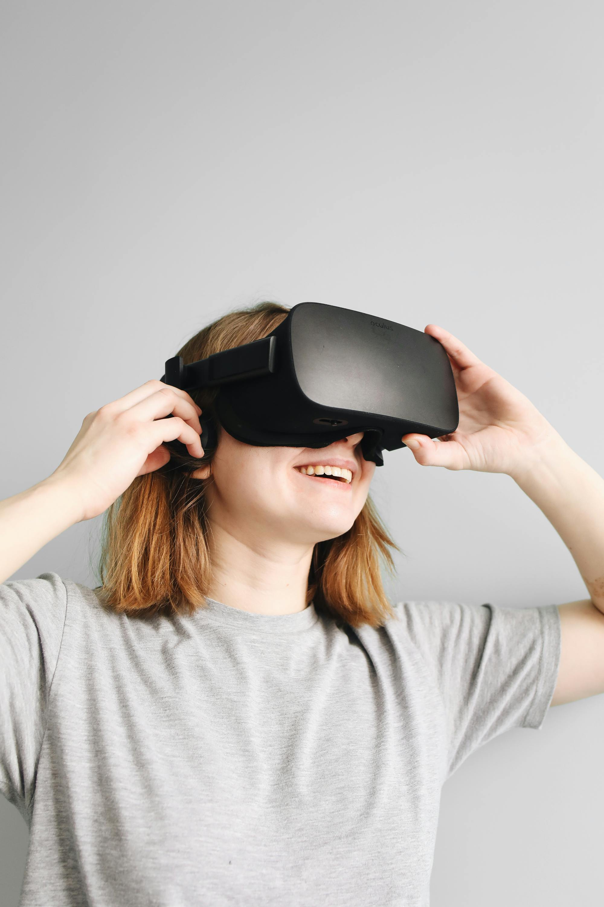 woman in gray crew neck shirt using virtual reality headset