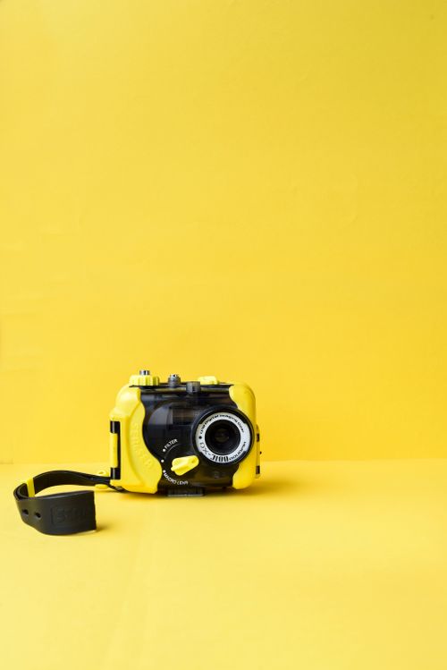 Free A yellow waterproof underwater camera on a vibrant backdrop. Stock Photo