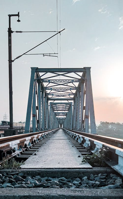 Railway bridge over river against sunset