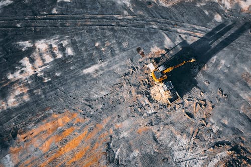 Free Aerial view of excavator working on big coal field of powerplant located in countryside Stock Photo