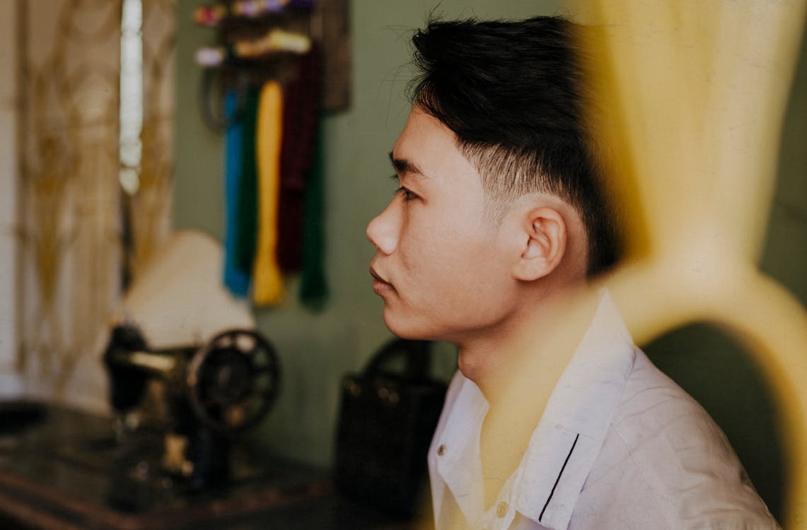 Dreamy Asian man with hairstyle resting at home