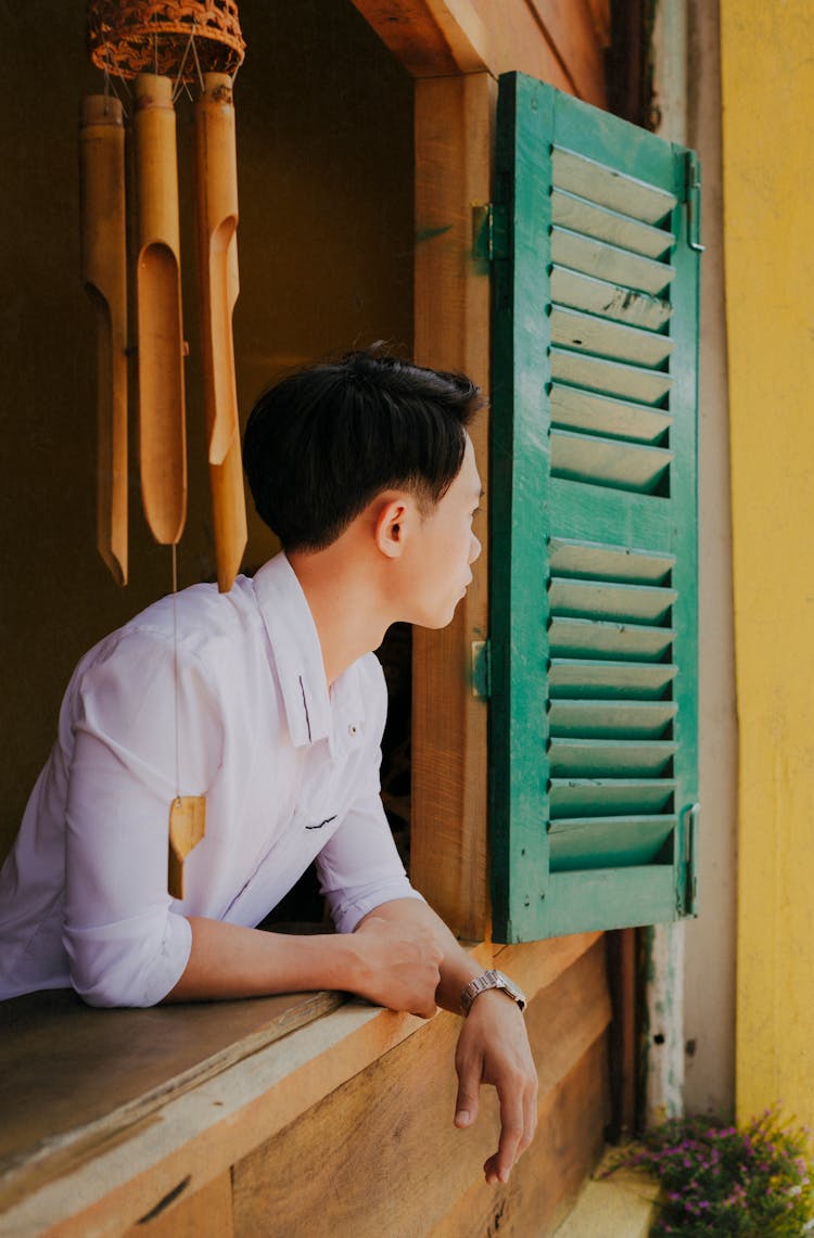 Unrecognizable Dreamy Ethnic Man Looking Out Window In House