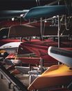 Rows of assorted colorful boats on platforms with ropes in harbor in town