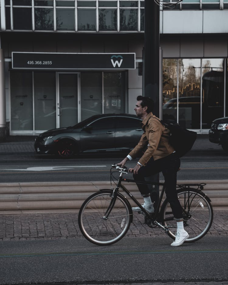 Stylish Delivery Man Riding Bicycle On City Road