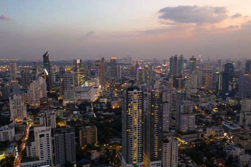 Free Remote picturesque scenery of contemporary city center with glowing skyscrapers and modern towers and buildings against cloudy sundown sky Stock Photo