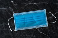Sterile mask on marble table during COVID 19 pandemic