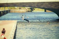 Man Wearing Blue Shirt Jumping on the Body of Water