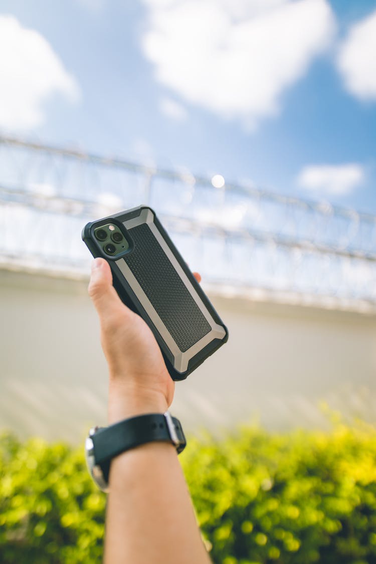 Crop Person Showing Contemporary Smartphone In Garden