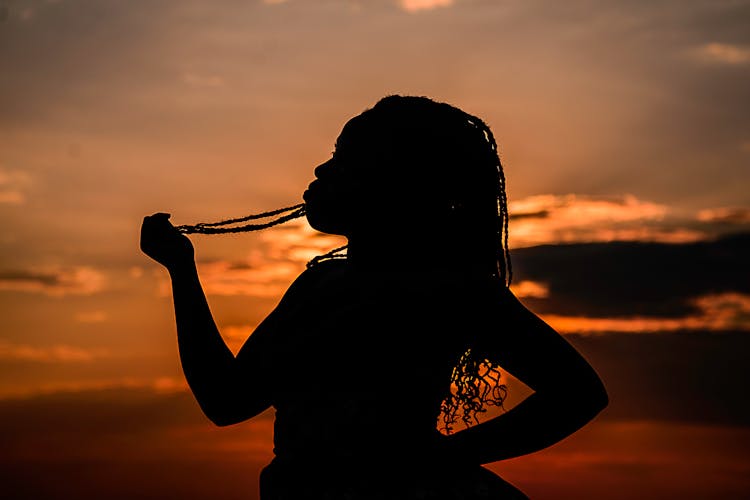Silhouette Of Unrecognizable African American Woman At Bright Sunset
