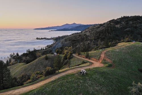 Free Drone view of picturesque scenery of hilly terrain in evening in summer time Stock Photo