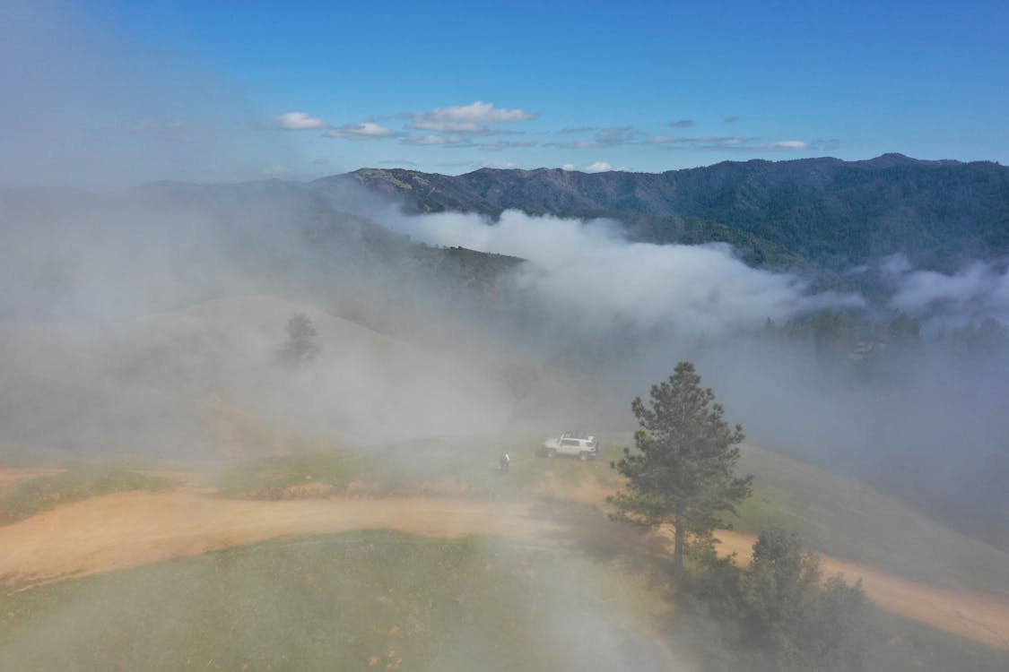 Free Aerial view of picturesque scenery of thick fog over green valley in summer day Stock Photo