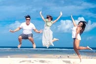 Woman and Man Jumping on Seashore