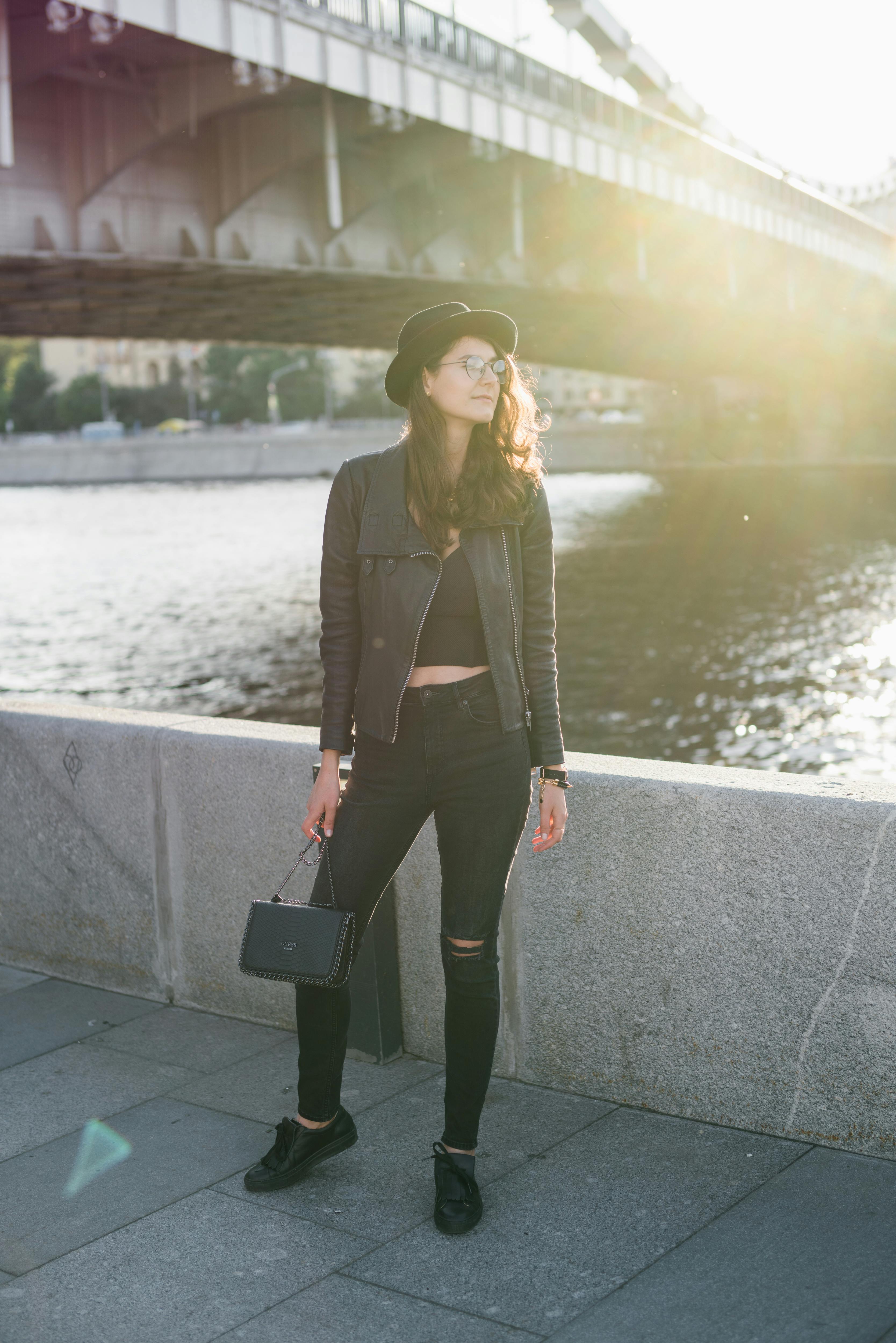 modern-girl-in-black-standing-on-river-embankment-in-back-lit-free