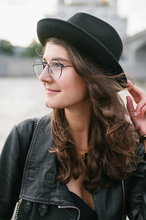 Positive woman in black looking away in city