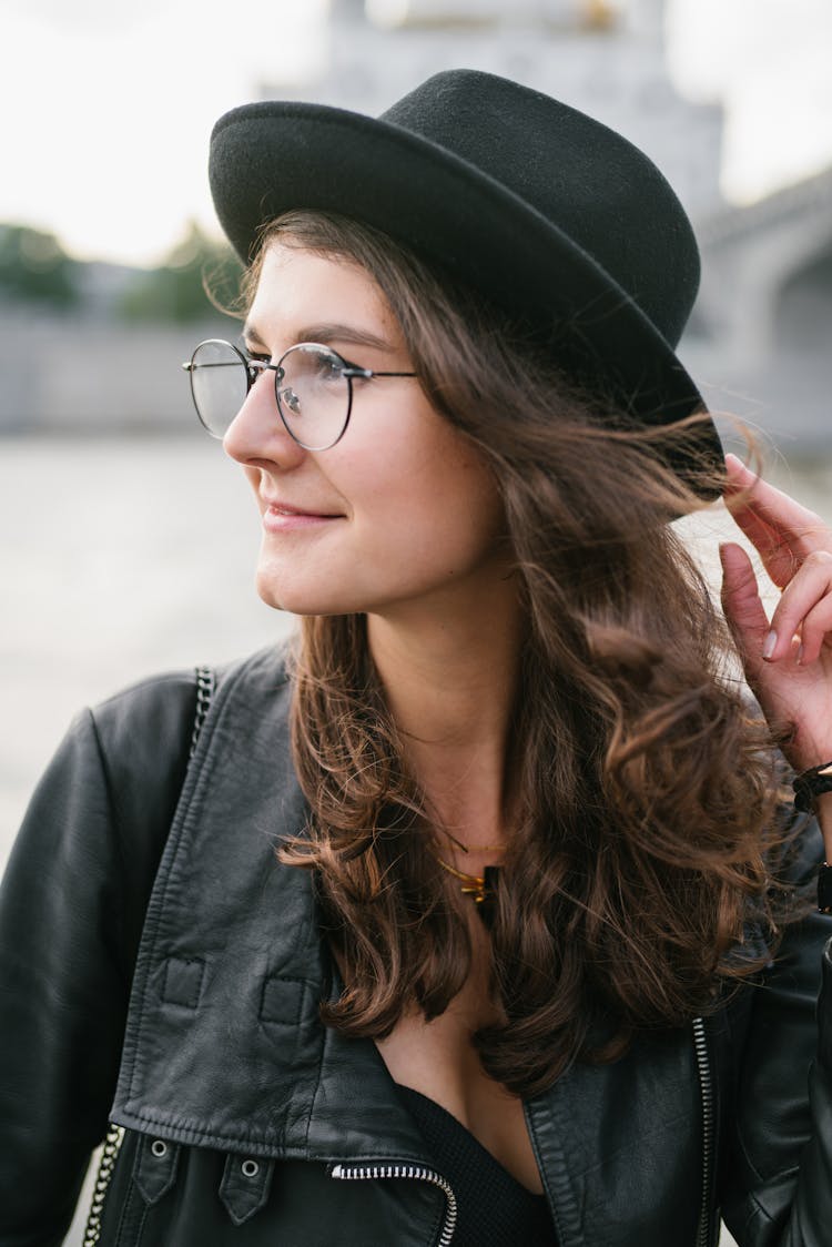 Positive Woman In Black Looking Away In City