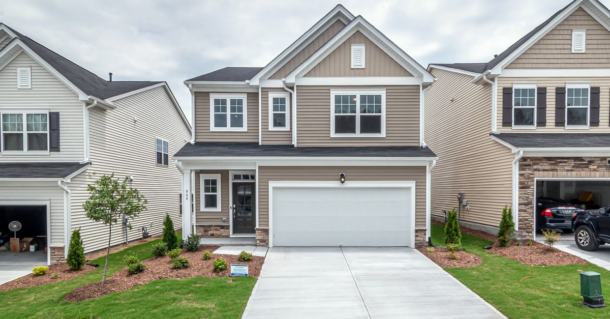 Newly built modern suburban house with a neat front yard and driveway.