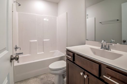 Clean and simple bathroom layout featuring a bathtub, sink, and toilet.