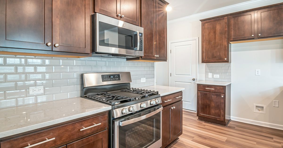 Sleek kitchen interior featuring stainless steel appliances and wooden cabinetry.