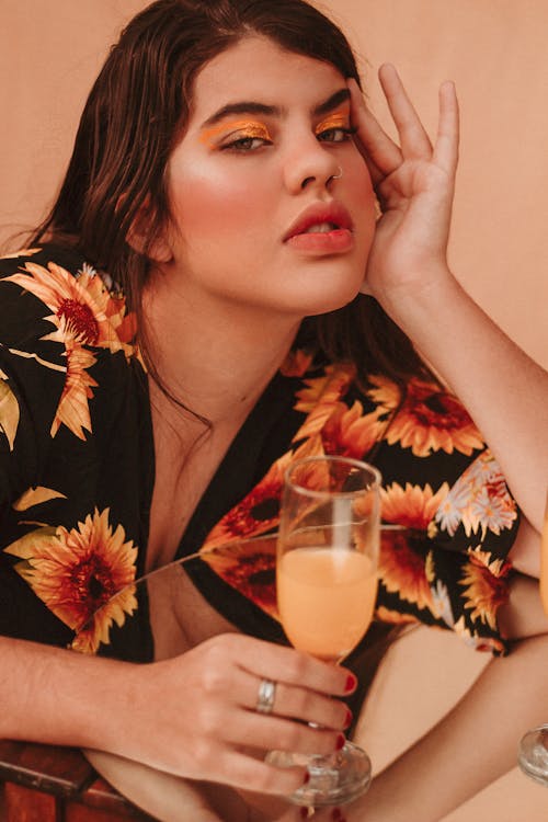 A Woman Wearing a Floral Top Holding a Drink