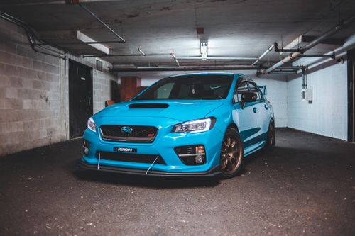 Free Trendy blue tuned sports car with glowing headlights and spoiler parked in garage Stock Photo