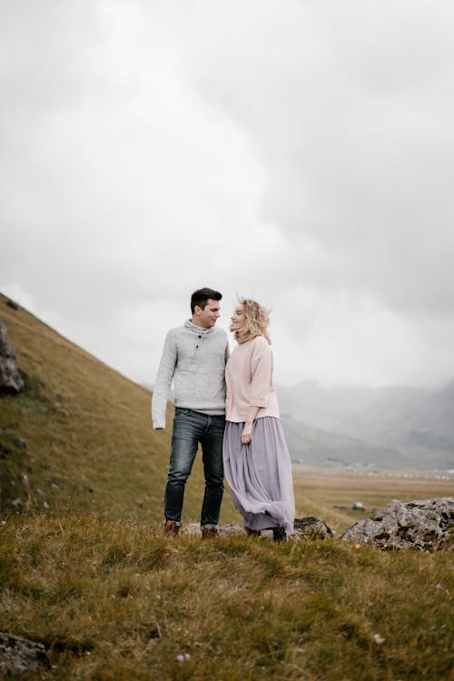 Free Romantic couple enjoying cloudy day on hilly landscape Stock Photo