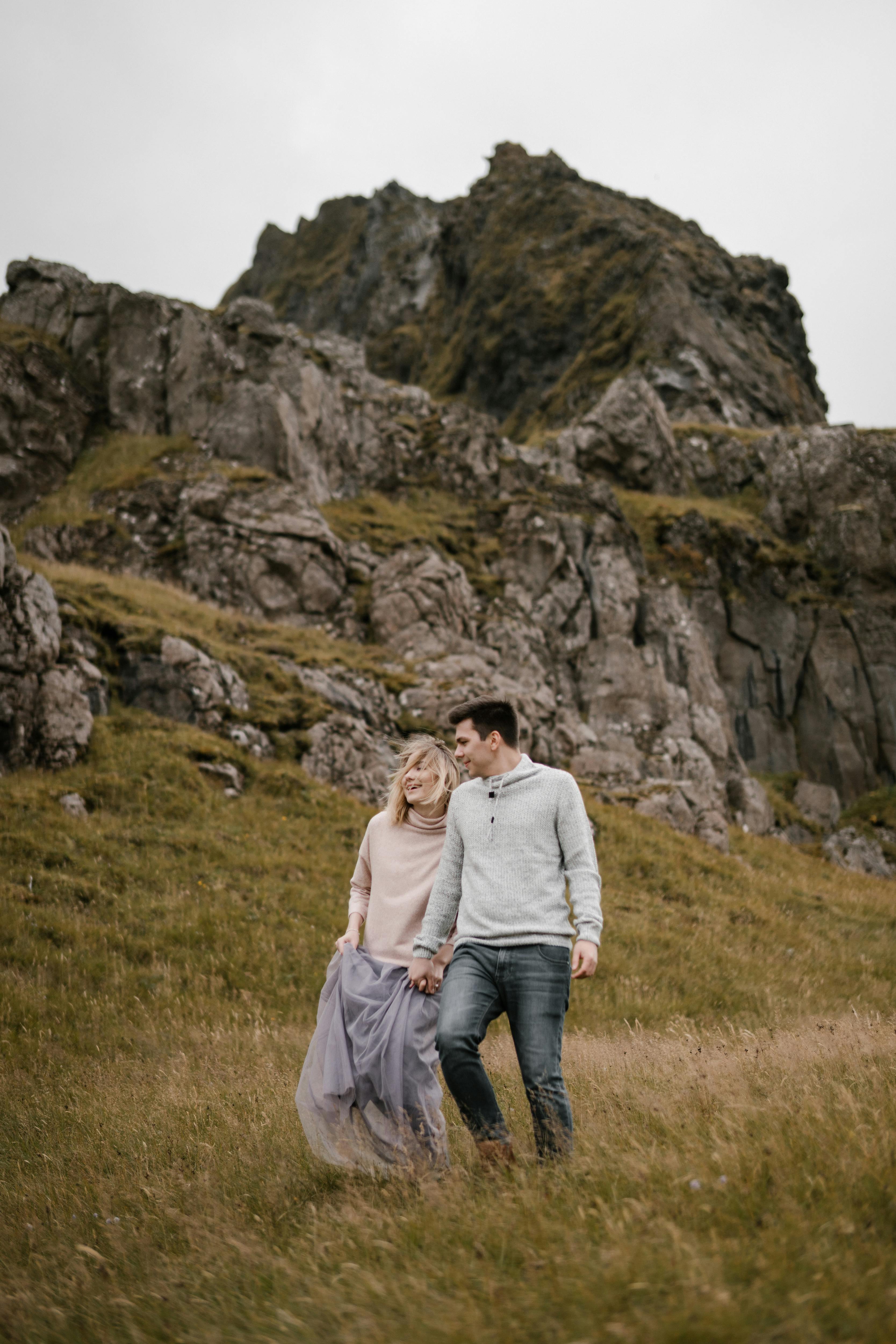 Happy Couple Walking Down Mountain Slope Free Stock Photo