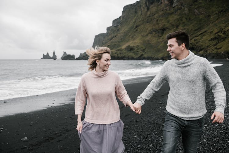 Happy Newlyweds Enjoying Honeymoon On Black Sandy Seashore In Autumn