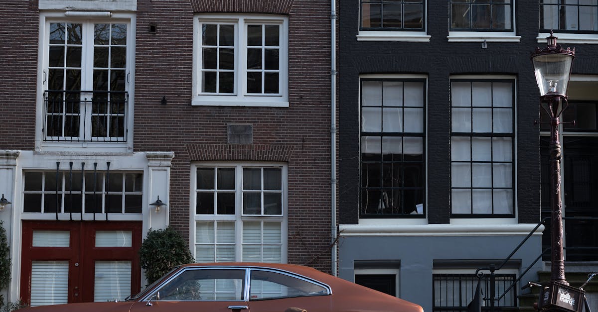 Man sitting on city riverside near retro car and boat · Free Stock Photo