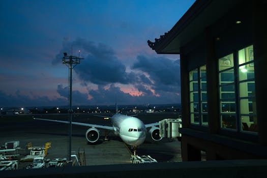 A plane parked at an airport terminal during twilight, showcasing modern travel infrastructure.