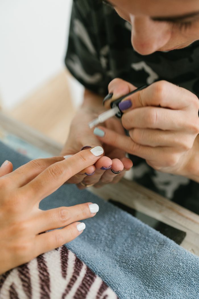 Manicurist carefully painting a client's nails