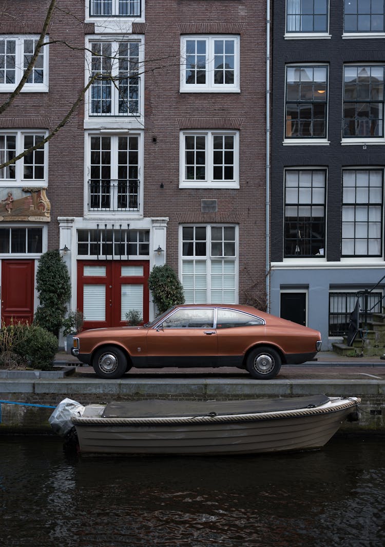 Retro Car Near Canal With Boat Against Narrow Cozy Houses