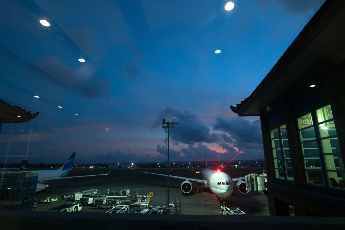 Airport apron and terminal illuminated at night