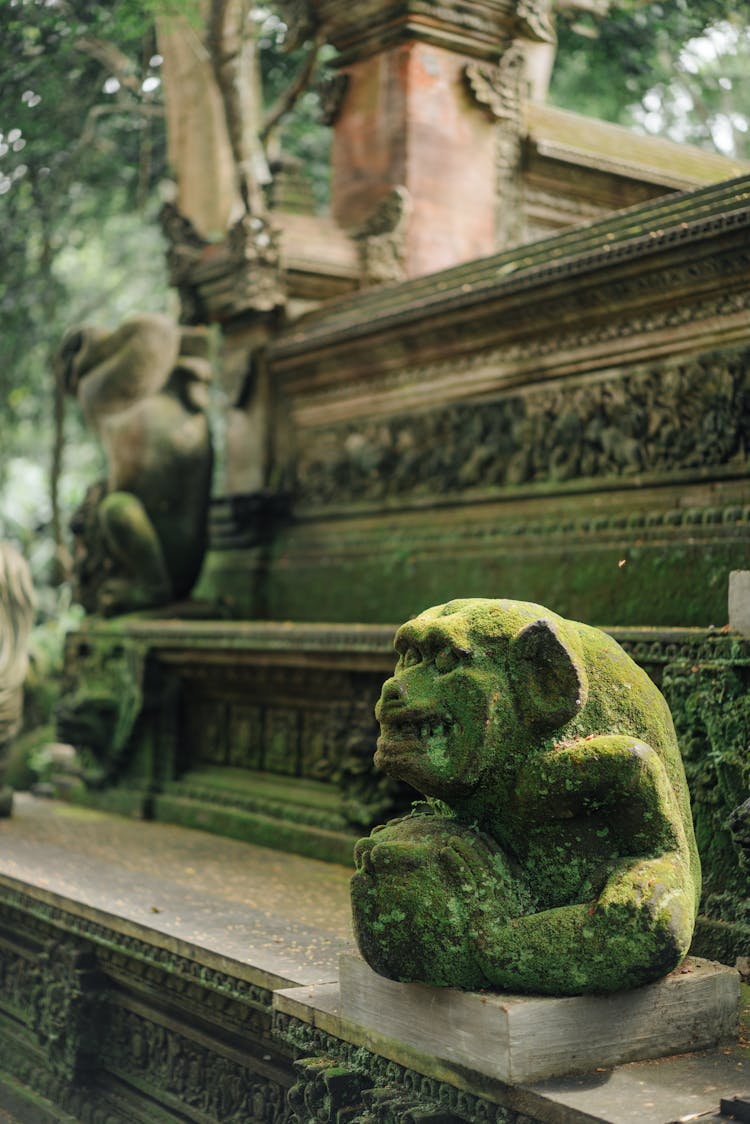 Old Mossy Monkey Statue In Tropical Garden