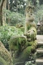 Traditional old statues of ancient mythological creatures located in green rainforest in tropical country on sunny day